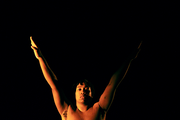 Bild von Eli Mathieu-Bustos während einer Choreografie, mit V-förmig erhobenen Armen, mit ruhigem Blick in die Kamera.
