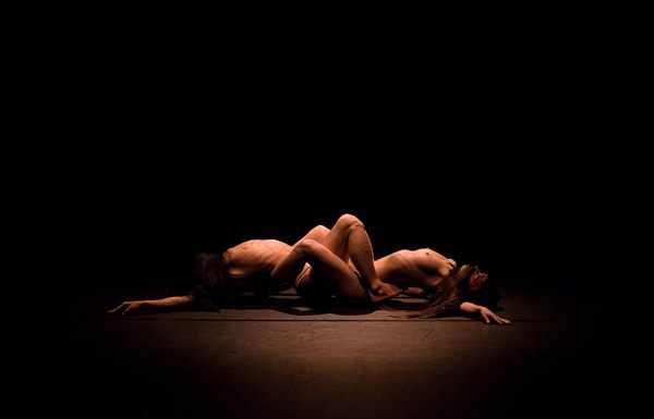 Photo of two naked entwined bodies on stage
