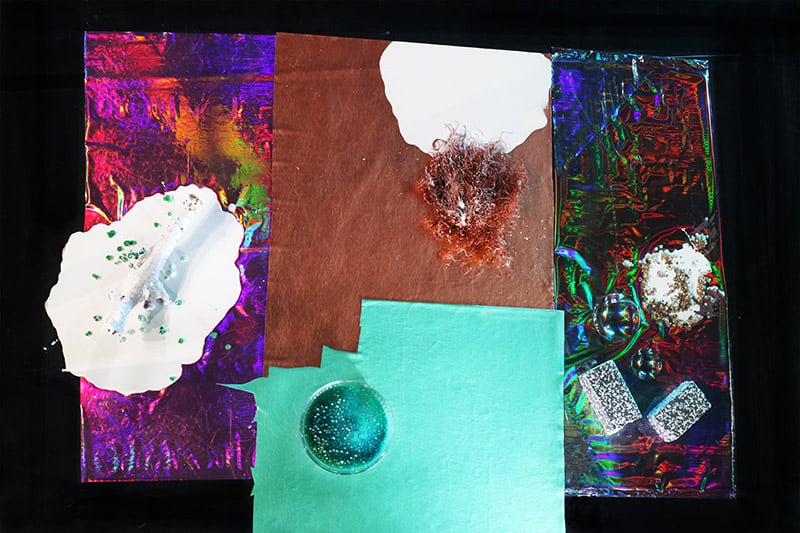 Colorful collage with different materials, textures and shapes. Surfaces with turquoise and brown, patterned with purple, white, red and green. 