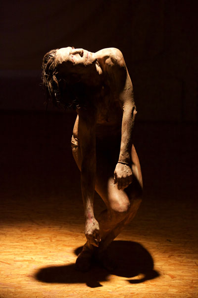 Foto eines halbnackten Tänzers in Pose im Bühnenraum. Spiel mit Licht und Schatten