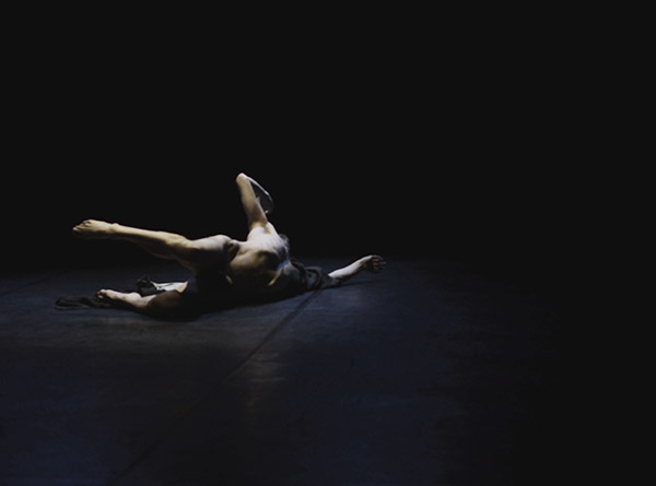 Foto eines nackten Tänzers in einer Pose am Boden