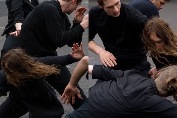 This photo is made from two similar vertical images placed together. It shows four people dressed in black, moving in an energetic way. Most faces are covered—some hidden by arms, some turned away, and one partially obscured by flowing hair.The background consists of grey asphalt. 