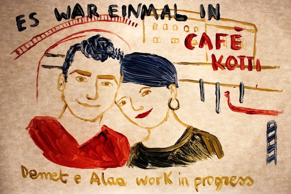 Gemalte Illustration zweier Personen vor dem Gebäude des Café Kotti in Berlin, darüber der Text „Es war einmal im Café Kotti“. Darunter steht „Demet e Alaa – work in progress“. Der Stil ist ausdrucksstark und handgemalt auf gealtertem Papier.